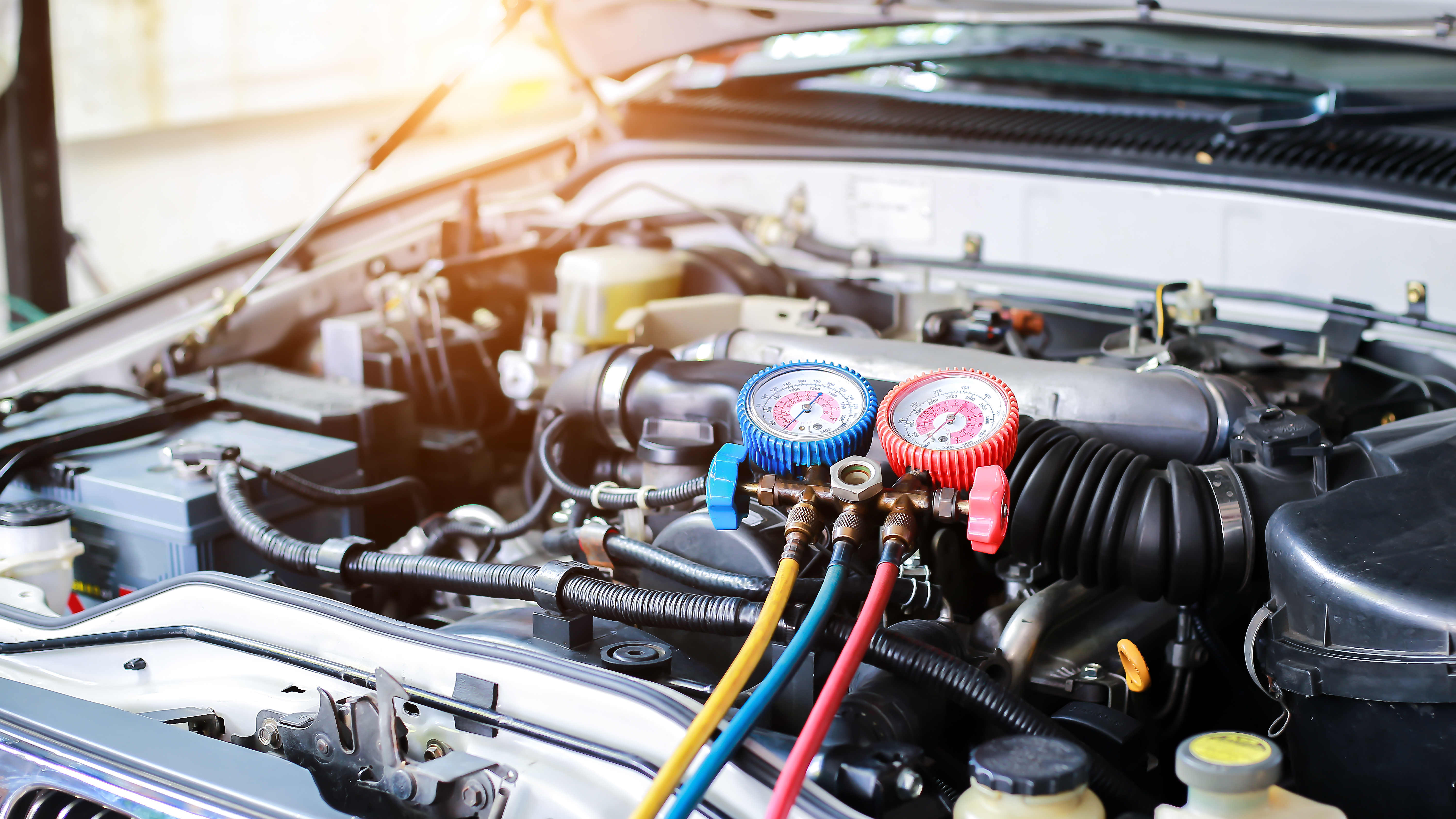 Automotive diagnostic manifold gauges connected to car engine during air conditioning system service